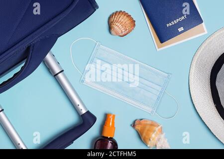 Accessori da viaggio con maschera facciale su sfondo blu Foto Stock