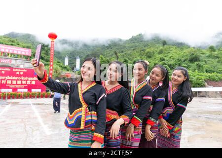 (200923) -- VIENTIANE, 23 settembre 2020 (Xinhua) -- le ragazze del Lao, nei loro abiti tradizionali festosi, posano per le foto alla cerimonia di perforazione-attraverso il tunnel di Ban Phoukeu tenuto all'uscita del tunnel a Muang Nga della provincia di Oudomxay, Laos, il 22 settembre 2020. Un'azienda di ingegneria ferroviaria cinese il martedì ha perforato attraverso il tunnel di Ban Phoukeu, l'ultimo grande tunnel lungo quasi 9,000 metri lungo la ferrovia Cina-Laos. Ha segnato un'importante pietra miliare nella costruzione della ferrovia transfrontaliera e ha gettato solide basi per il tempestivo completamento del mega progetto. (Foto di Kaikeo Foto Stock