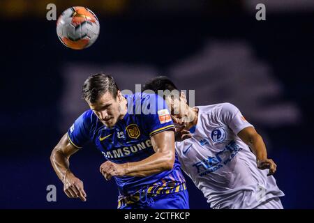 Il calciatore croato Ivan Santini di Jiangsu Suning F.C., a sinistra, lotta per una palla di testa durante la terza partita del 2020 Super Leagu cinese Foto Stock