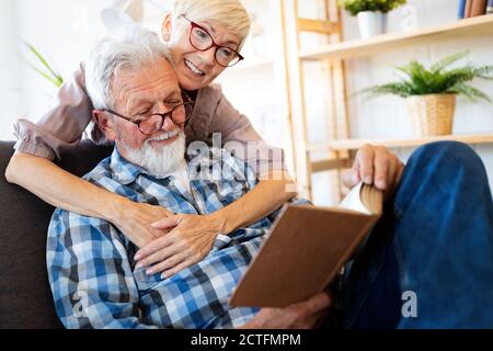 Coppia matura rilassante a casa e leggere libro insieme Foto Stock