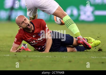 Il calciatore polacco Adrian Mierzejewski di Chongqing SWM cade sopra il terreno dopo essere stato calciato durante la quarta partita di 2020 cinese Super Foto Stock