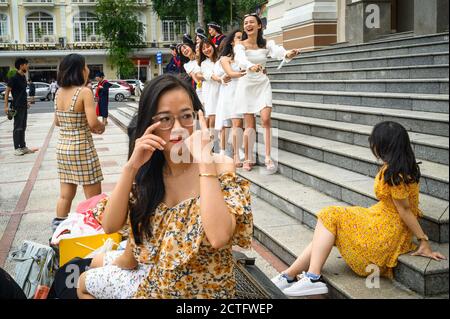 Giovani donne in posa di fronte al Teatro dell'Opera, ho Chi Minh City, Vietnam Foto Stock