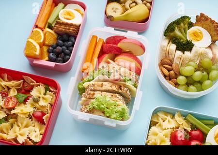 Modello di vista dall'alto di lunchbox da ufficio con vari nutrienti sani pasti su sfondo blu Foto Stock