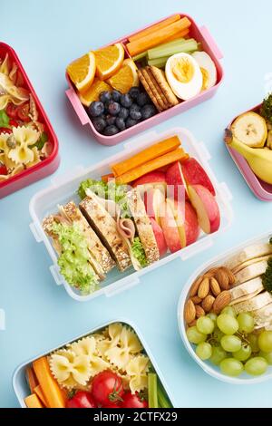 Modello di vista dall'alto di lunchbox da ufficio con vari nutrienti sani pasti su sfondo blu Foto Stock