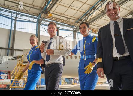 I membri dell'equipaggio di cabina sono felici e cordiali e si trovano in aeroporto Foto Stock