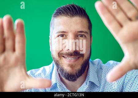 Uomo maturo bearded con bretelle che si divertono a fare una cornice con le mani Foto Stock