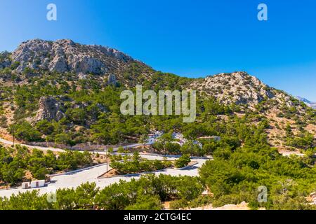 Vista panoramica della piccola chiesa rossa di Panagia Lamiotissa con ampia area salotto per le celebrazioni sull'isola di Karpathos, Grecia Foto Stock