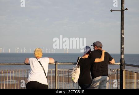 La gente ammira la vista alla fine di una giornata di sole nella località balneare di Skegness, Lincolnshire Foto Stock