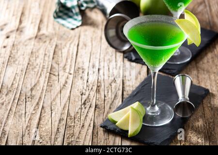 Cocktail di appletini verdi in vetro su tavolo di legno. Spazio di copia Foto Stock