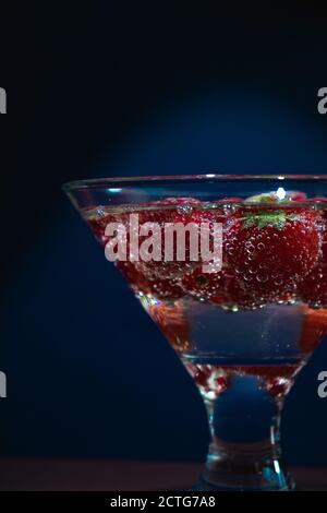 Fragole frutti in Champagne, vetro trasparente, sfondo Foto Stock