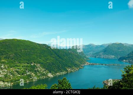 Aerail Vista su Lugano con Lago Alpino e montagna in una giornata di sole in Ticino, Svizzera. Foto Stock