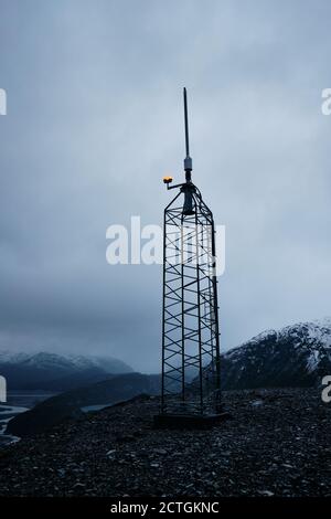 vista oscura e dall'umore di una torre di comunicazione teleobiettivo su una giornata nuvolosa Foto Stock