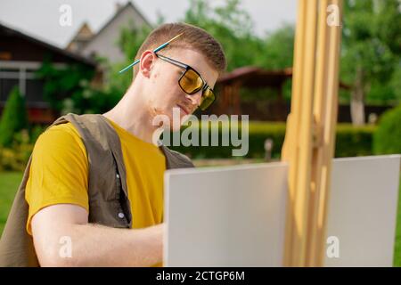 L'artista maschile crea l'arte all'aria aperta. Hobby di disegno Foto Stock