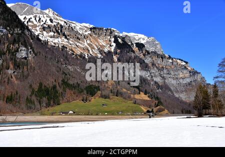 Panorama delle Alpi dal lago Klontalersee in primo piano in primavera soleggiato giorno in Klöntal, Alpi Svitto, cantone Glarona, Svizzera. Foto Stock
