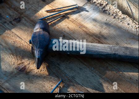Vecchio martello e chiodi vintage su sfondo di legno, primo piano, fuoco selettivo Foto Stock