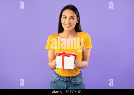 Donna felice che tiene la scatola del regalo allo studio Foto Stock