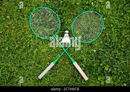 Racchette di badminton incrociate e shuttlecock su erba verde, gioco di Badminton, sport Foto Stock
