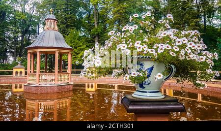 Gazebo in legno e vaso con fiori decorato con aquila a doppia testa nel Giardino d'Estate, San Pietroburgo, Russia Foto Stock