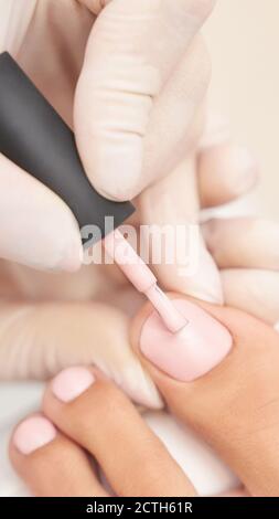 Manicure classica con unghie rosa su sfondo bianco. Concetto di trattamento spa Foto Stock