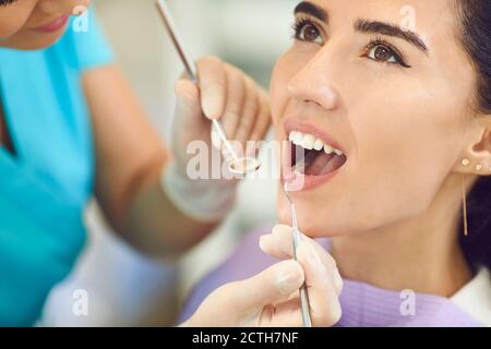 Trattamento dentale in clinica. Il dentista tratta i denti ad una ragazza giovane nell'ufficio di una clinica dentale Foto Stock