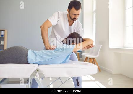 Medico professionista che fa la regolazione chiropratica posteriore alla paziente femminile dentro moderno centro benessere Foto Stock