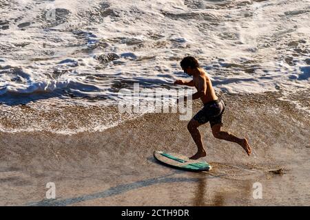 Malibu, California, Stati Uniti. 15 marzo 2019. Un surfista corre mentre sta per navigare a Malibu. Credit: Ronen Tivony/SOPA Images/ZUMA Wire/Alamy Live News Foto Stock