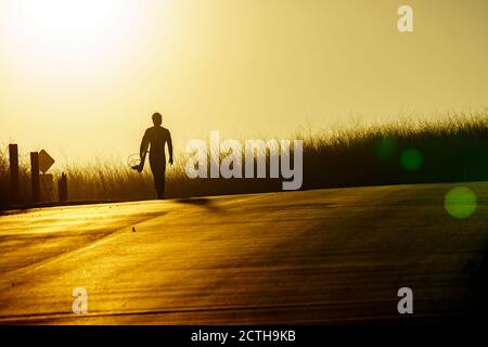 Malibu, California, Stati Uniti. 15 marzo 2019. Un surfista cammina verso la spiaggia durante il tramonto a Malibu. Credit: Ronen Tivony/SOPA Images/ZUMA Wire/Alamy Live News Foto Stock