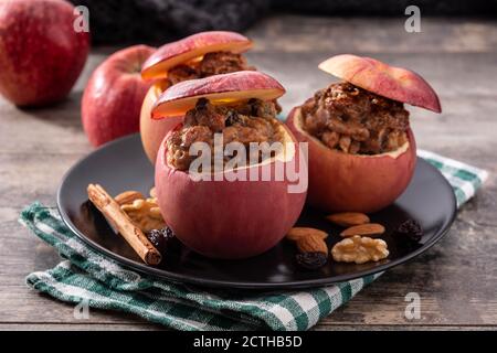 Mele ripiene cotte con noci su tavola di legno. Foto Stock