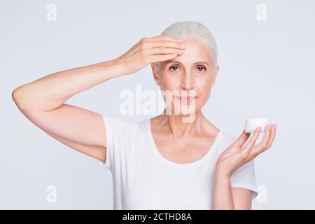 Primo piano foto di una persona affascinante che applica gel nutriente indossando elegante t-shirt trendy isolata su sfondo bianco Foto Stock