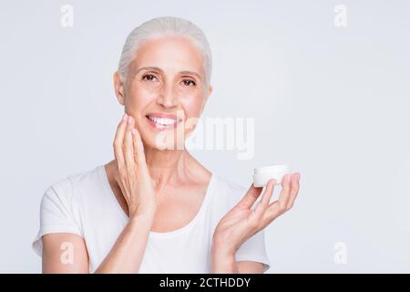 Primo piano foto di attraente donna che applica il nutrimento quotidiano indossare elegante abbigliamento alla moda isolato su sfondo bianco Foto Stock