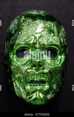 Maschera Zombie verde metallizzata isolata contro sfondo nero Foto Stock