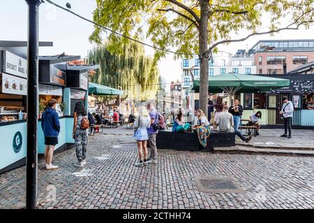 Giovani che si affacciano al mercato di Camden Lock in un pomeriggio insolitamente caldo di fine settembre, Londra, Regno Unito Foto Stock