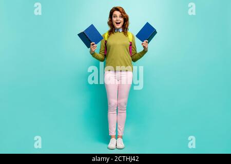 Vista a tutta lunghezza del corpo della sua bella lei eccitato intellettuale allegro cheery girl ondulato-capelli libro di lettura avendo divertimento isolato acceso luminoso Foto Stock