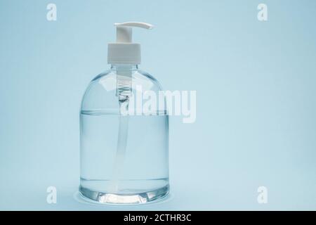 Dispenser di gel antibatterico su fondo blu Foto Stock