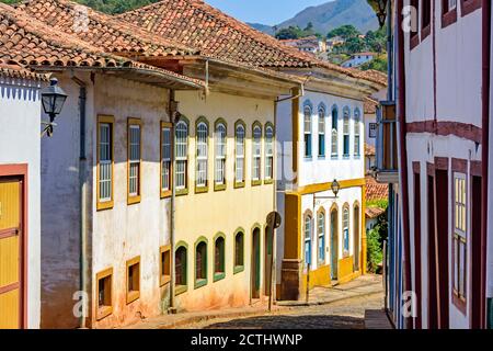 Strada tranquilla con vecchie case colorate in architettura coloniale, ciottoli e lanterne per l'illuminazione Foto Stock