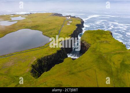 Guardando giù sul Geo di Calder e faro sulla costa di Eshaness a Northmavine , terraferma settentrionale delle Isole Shetland, Scozia, Regno Unito Foto Stock