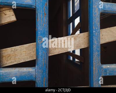 Cornici di legno blu dalle finestre su una parete nera sfondo Foto Stock