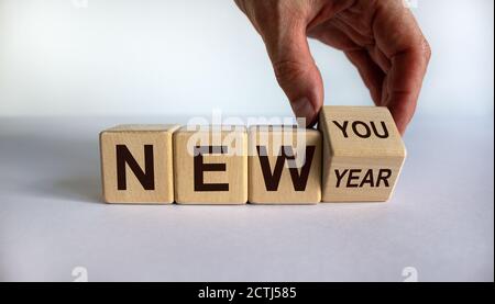 Hand trasforma un cubo e cambia l'espressione "nuovo anno" in "nuovo te". Splendido sfondo bianco. Spazio di copia. Concetto aziendale. Foto Stock