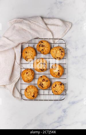 Biscotti di Natale fatti in casa appena sfornati con mirtilli rossi, mandorle e cioccolato bianco su sfondo marmoreo. Delizioso biscotto natalizio. Pani di zenzero Foto Stock