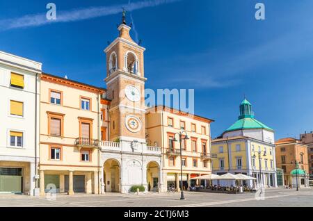 Piazza tre Martiri Piazza dei tre Martiri con edifici tradizionali con orologio e campanile nel centro storico turistico di Rimini con sfondo blu cielo, Emilia-Romagna, Italia Foto Stock