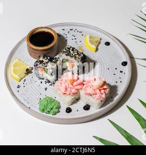 La composizione dei rotoli di sushi su piastra di ceramica leggera. Menu sushi. Cibo giapponese Foto Stock