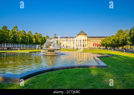 Wiesbaden, Germania, 24 agosto 2019: Kurhaus o curativo casa spa e casinò edificio e Bowling Green parco con prato erboso, vicolo alberi e stagno con fontana nel centro storico della città, stato di Assia Foto Stock