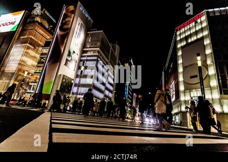 Tokyo, Giappone - 14 Gennaio 2010: pedoni che attraversano la strada nel cuore del quartiere di Ginza a Tokyo. Ginza attraversando la notte. Moto sfocata. Foto Stock