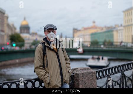 Uomo maturo con respiratore nel centro di San Pietroburgo. Nuova normalità durante la pandemia COVID-19 Foto Stock