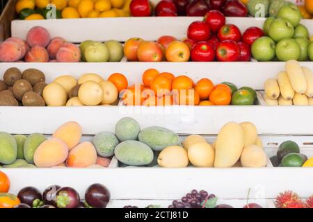 Molti frutti freschi di stagione per la vendita esposti su uno stand presso un mercato agricolo locale. Foto Stock