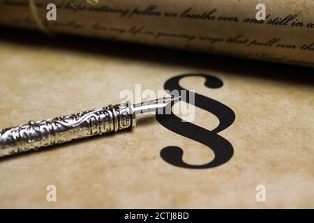 Closeup del segno di paragrafo isolato su carta d'epoca con penna d'inchiostro retrò argentata e documento di testo (Focus sulla punta della penna d'inchiostro, il testo è fatto da solo) Foto Stock