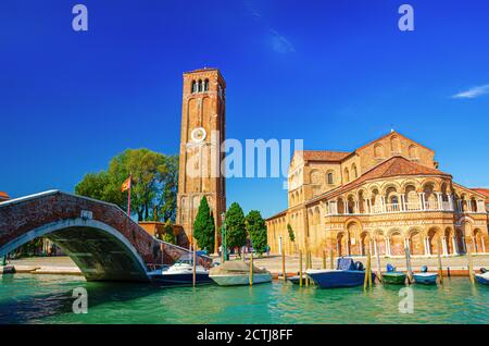 Chiesa di Santa Maria e San Donato e campanile in mattoni, ponte attraverso il canale d'acqua con barche a motore nelle isole Murano, provincia di Venezia, Regione Veneto, Italia settentrionale. Murano cartolina. Foto Stock