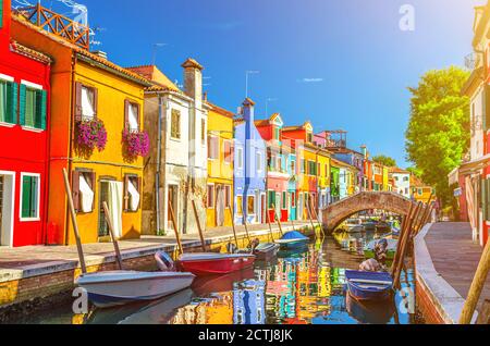 Case colorate dell'isola di Burano. Edifici multicolore su argine di fondamenta, stretto canale d'acqua con barche da pesca e ponte di pietra, provincia di Venezia, Regione Veneto, Italia. Burano cartolina Foto Stock