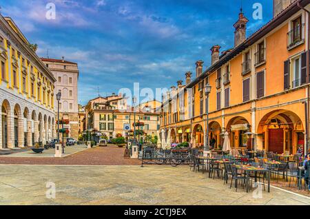 Tipici edifici italiani e tavoli di ristoranti di strada in Piazza del mercato Piazza del mercato nel centro storico di Brescia, vista serale al crepuscolo, via italiana, Lombardia, Italia settentrionale Foto Stock