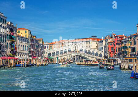 Venezia, Italia, 13 settembre 2019: Paesaggio urbano con il Ponte di Rialto attraverso il Canal Grande, architettura veneziana edifici colorati, gondole, barche, vaporetti ormeggiati e vela Canal Grande Foto Stock